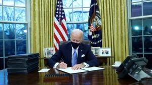 Biden, en el Despacho Oval, firma sus primeras órdenes.