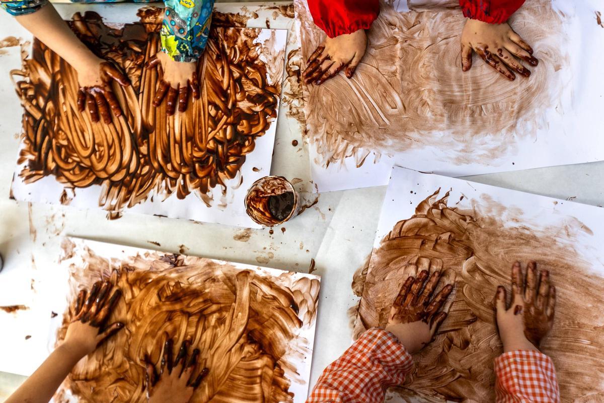 Alumnos de educación infantil haciendo una actividad con chocolate en la escuela.
