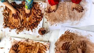 Alumnos de educación infantil haciendo una actividad con chocolate en la escuela.