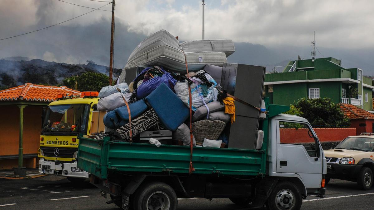 Camiones con las pertenencias de los vecinos del núcleo urbano de Todoque durante el desalojo de sus viviendas ante la aproximación de la lava del volcán