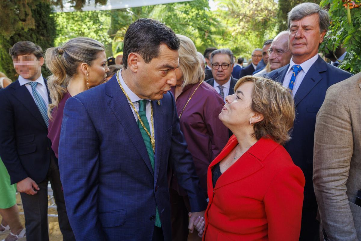 SEVILLA, 05/07/2026.- El nuevo presidente de la Junta de Andalucía, Juanma Moreno (i), conversa con la exministra Soraya Sáenz de Santamaría (d) tras su ceremonia de toma de posesión, este domingo en los jardines del Palacio de San Telmo, sede de la Presidencia de la comunidad, en Sevilla. EFE/Julio Muñoz