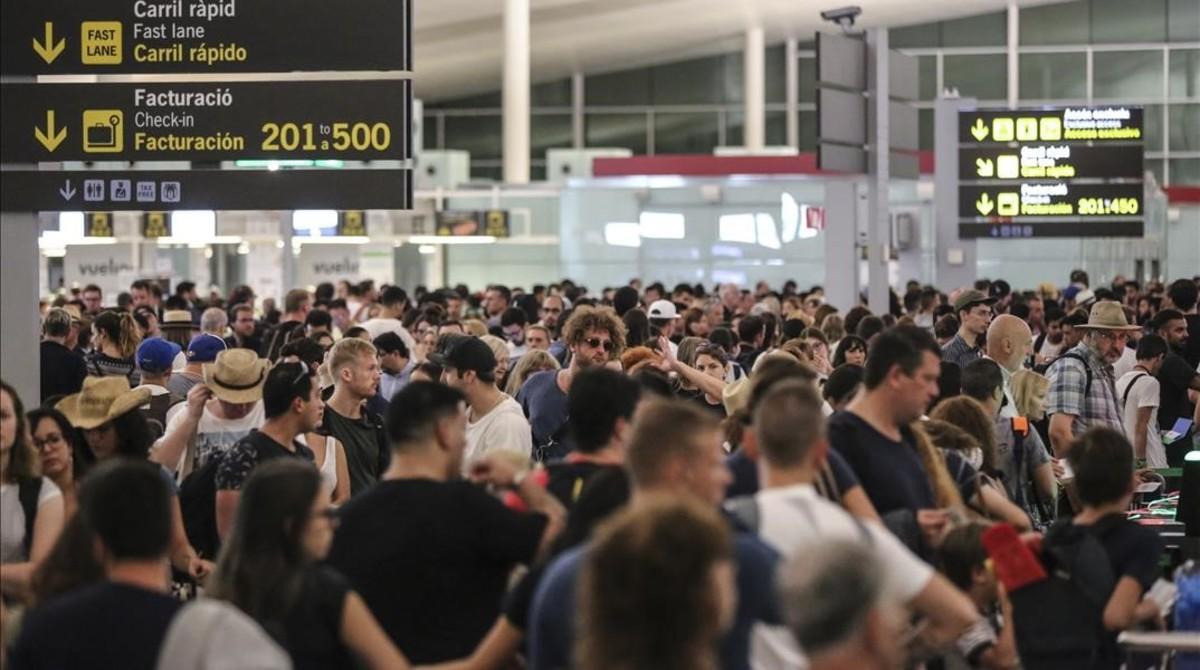 Aglomeración de viajeros en los controles de seguridad de la T-1 del aeropuerto de El Prat, el viernes.