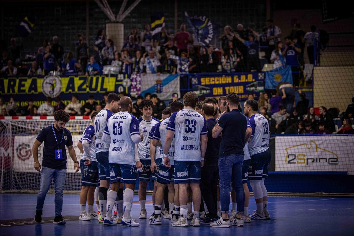 El entrenador del Frigoríficos del Morrazo, Quique Domínguez, da instrucciones a sus jugadores durante un tiempo muerto. Al fondo, los aficionados de Cangas que viajaron a Guadalajara.