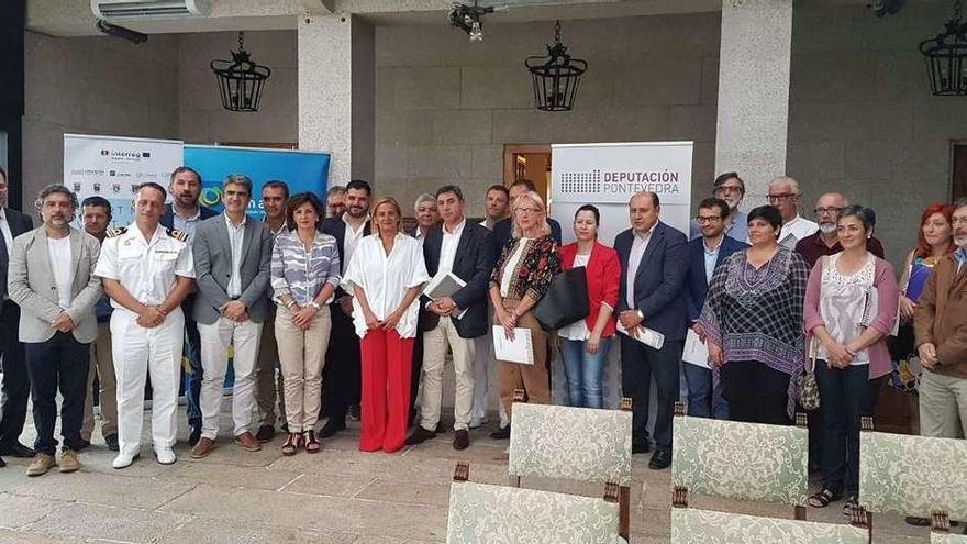 La presidenta de la Diputación, Carmela Silva, y el diputado Uxío Benítez posan con alcaldes de municipios de Galicia y Portugal en una foto de familia, ayer, en el Parador de Tui. // D.B.M.