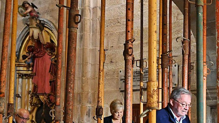 El párroco y unos feligreses en la iglesia de Salcedo.