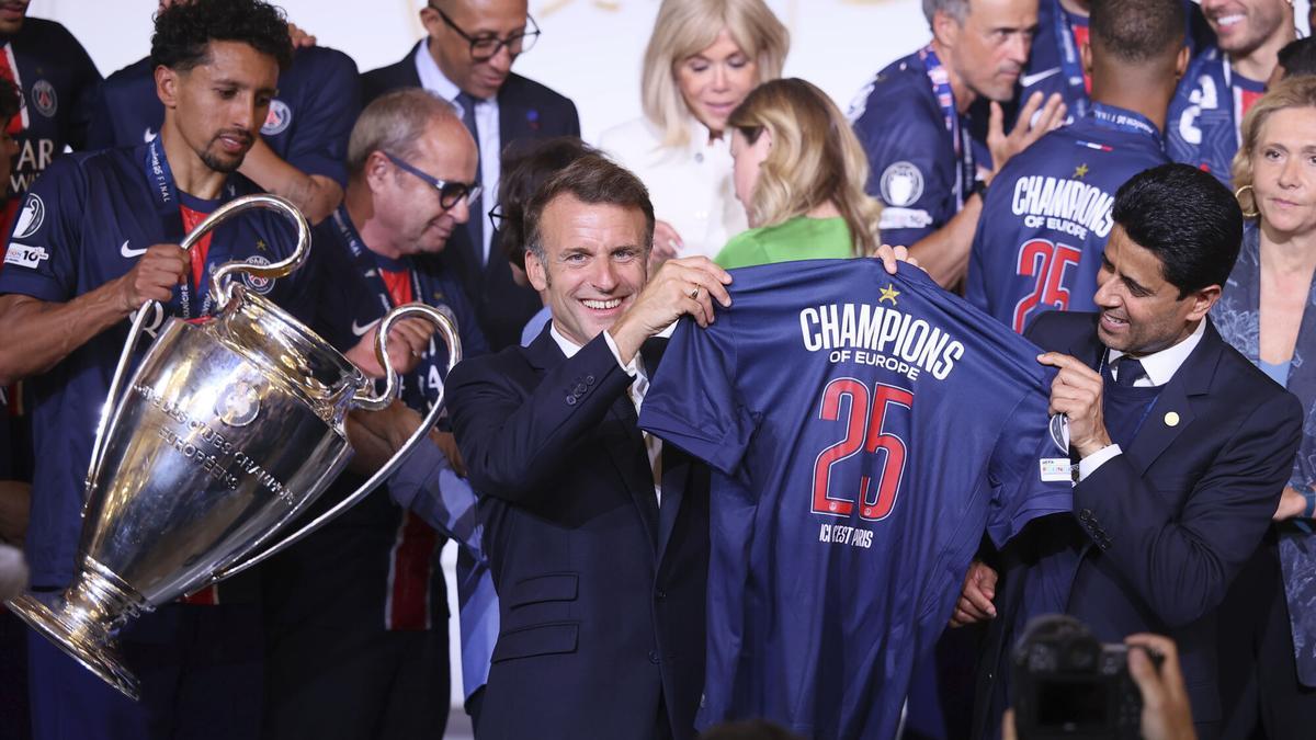 El presidente francés, Emmanuel Macron, y el presidente catarí del Paris Saint-Germain, Nasser al-Khelaifi, sostienen una camiseta del equipo parisino durante la recepción en el Palacio del Elíseo en París.
