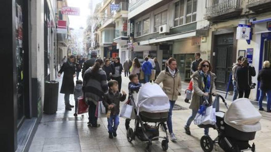 Dos mujeres con dos carritos y dos niños, en la calle Major de Gandia.