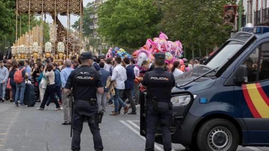 Agentes de policía vigilan una procesión en Sevilla, ayer.