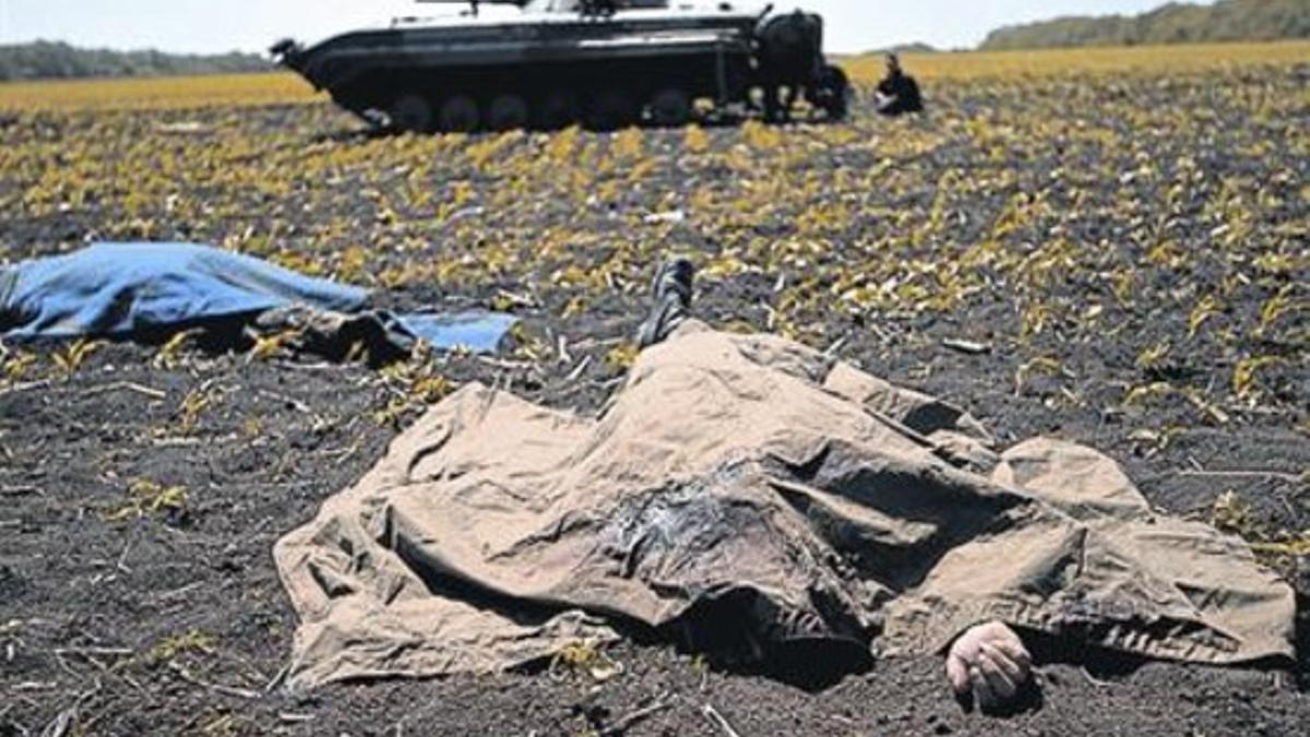 El cuerpo de uno de los soldados muertos ayer cubierto con una manta.