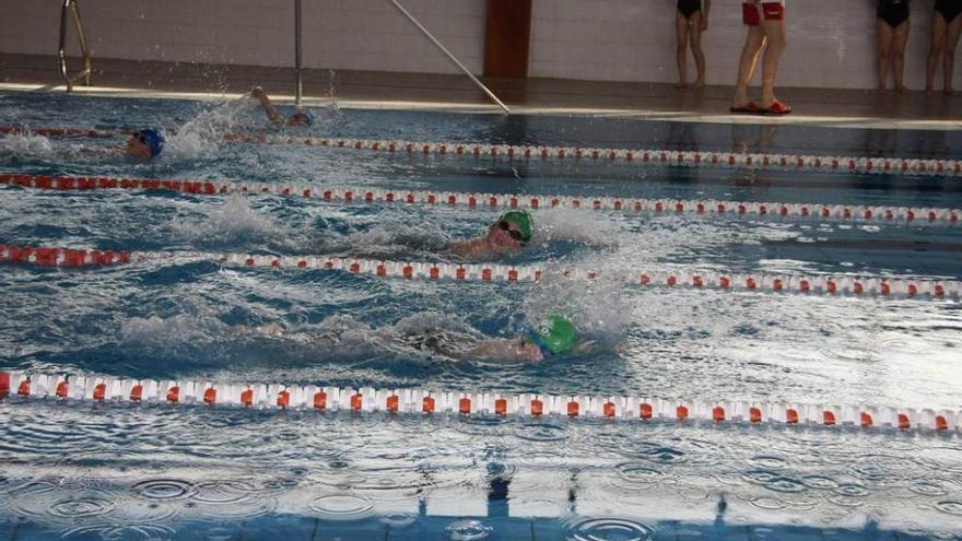 Varios niños, practicando la natación en la piscina de Laviana.