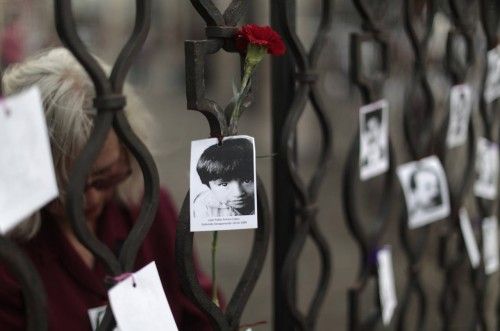 A photo of a person who disappeared in the country's internal armed conflict is attached to a flower on the fence of the cathedral in Guatemala City, during commemorations on the anniversary of the publication of the Diario Militar