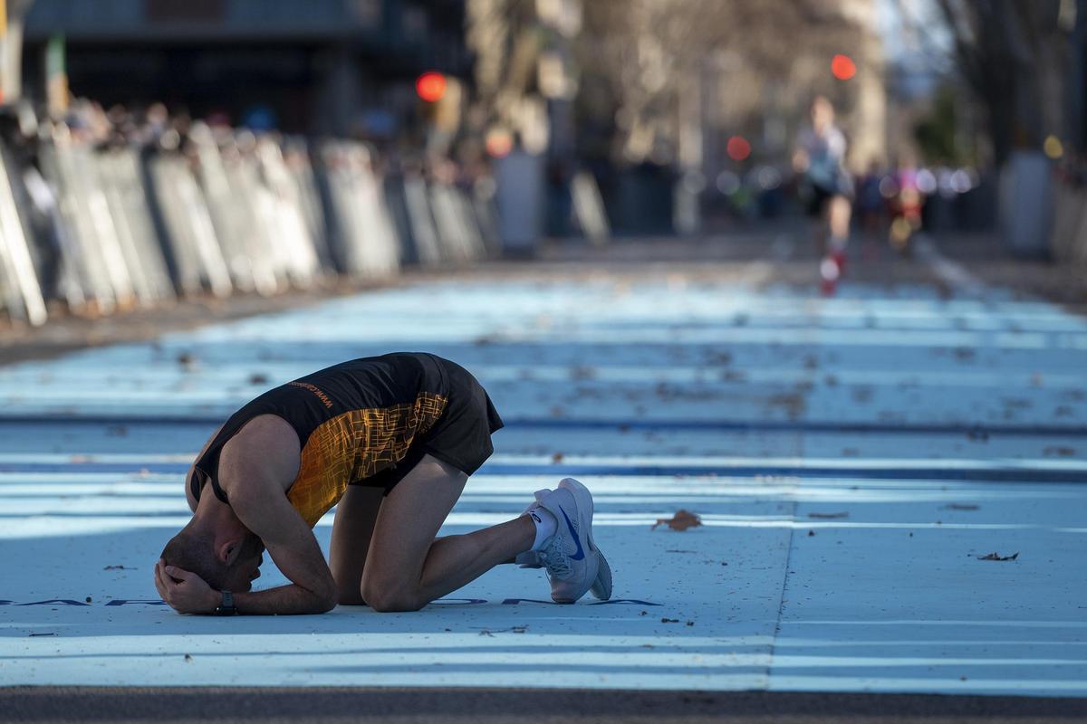 Un corredor exhausto tras cruzar la línea de meta en la media maratón de Barcelona.