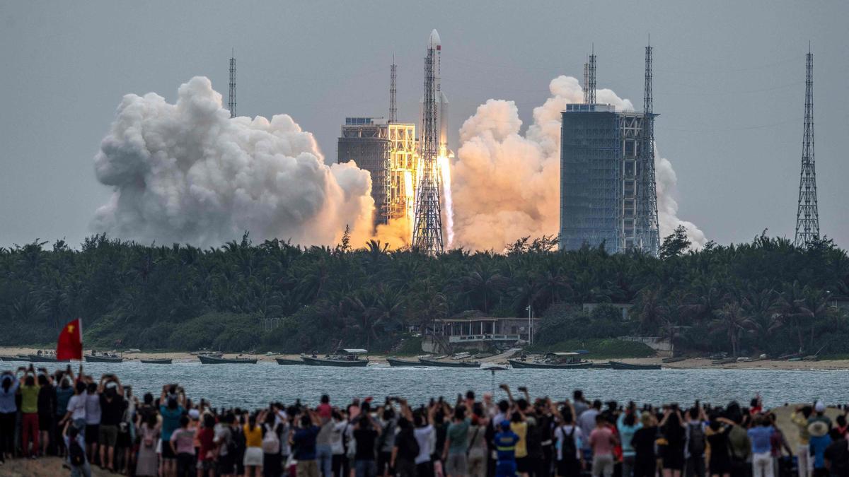 Un grupo de personas observa el despegue del cohete chino Long March 5b en la lanzadera espacial de Wenchang.