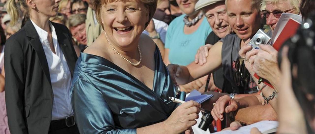 Angela Merkel firmando autógrafos en Bayreuth en 2012.