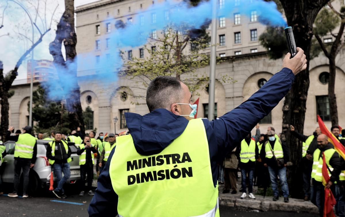 Un manifestante durante la protesta de transportistas con una bengala en la mano y un chaleco en el que se puede leer &quot;ministra dimisión&quot;.