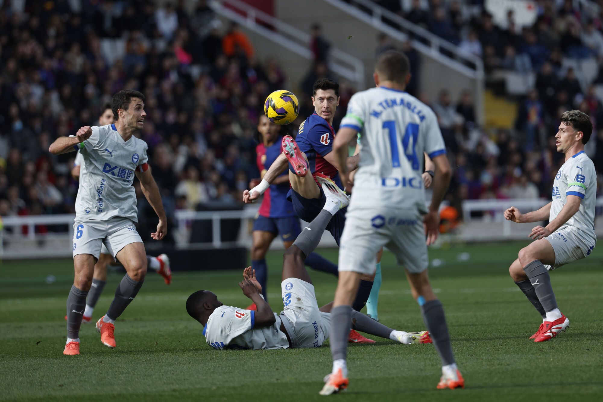 Barcelona's Robert Lewandowski, centre, challenges for the ball during a Spanish La Liga soccer match between Barcelona and Alaves at the Lluis Companys Olympic Stadium in Barcelona, Spain, Sunday Feb. 2, 2025. (AP Photo/Joan Monfort)