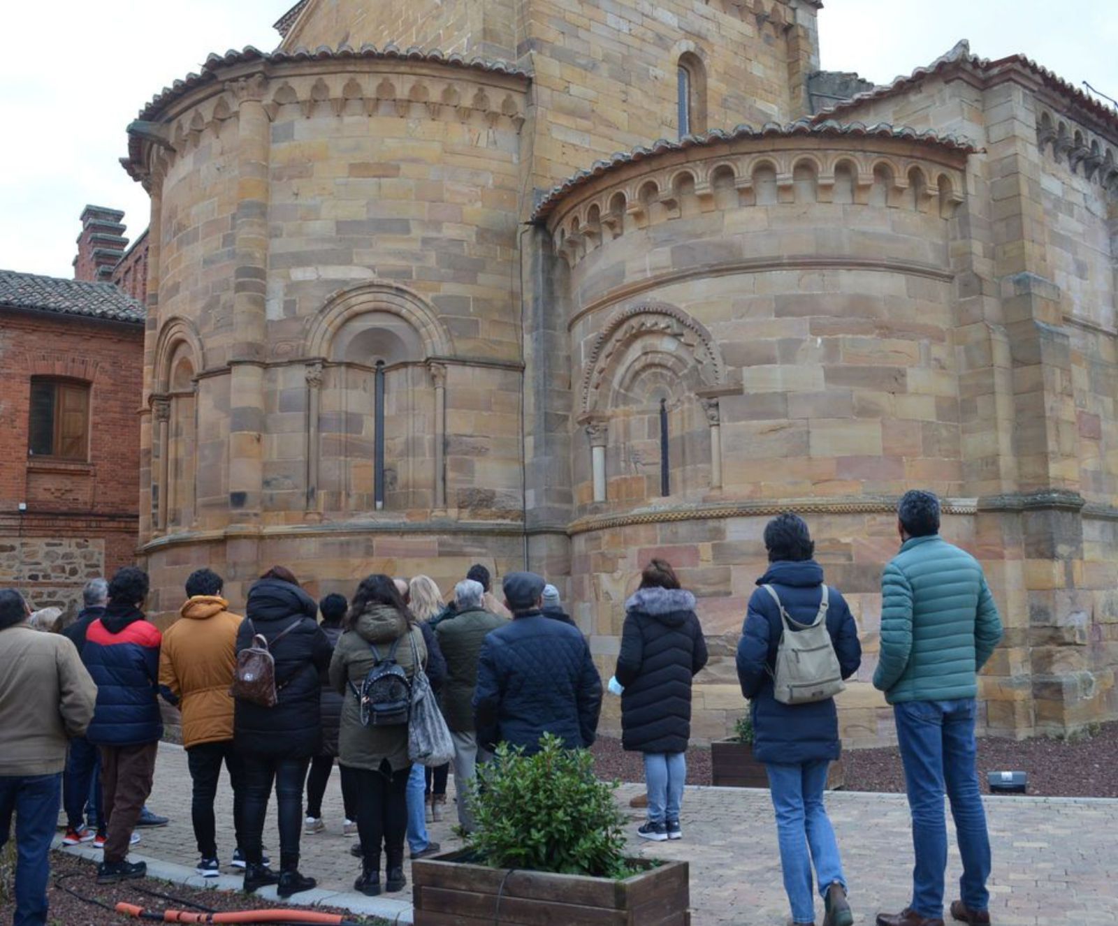 El grupo participante contempla los ábsides de la iglesia de San Juan de Benavente. | E. P.