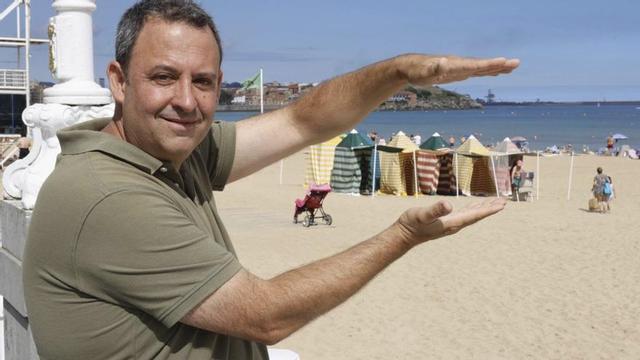 Juan Varas, en la playa de San Lorenzo, junto a las tradicionales casetas.