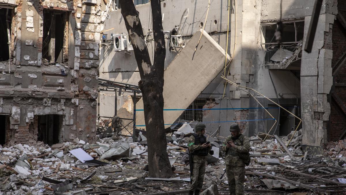 Dos soldados ucranianos en medio de los escombros en la ciudad de Járkov.