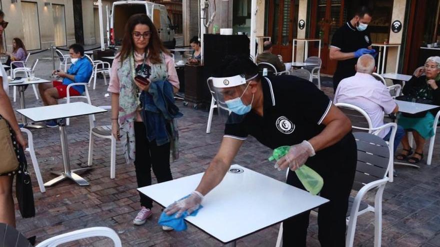 Un camarero limpia una mesa de la terraza del Café Central, en la plaza de la Constitución.