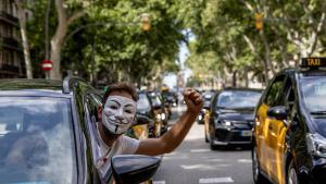 Uno de los taxistas que este martes han participado en la marcha lenta de taxistas por las calles de Barcelona