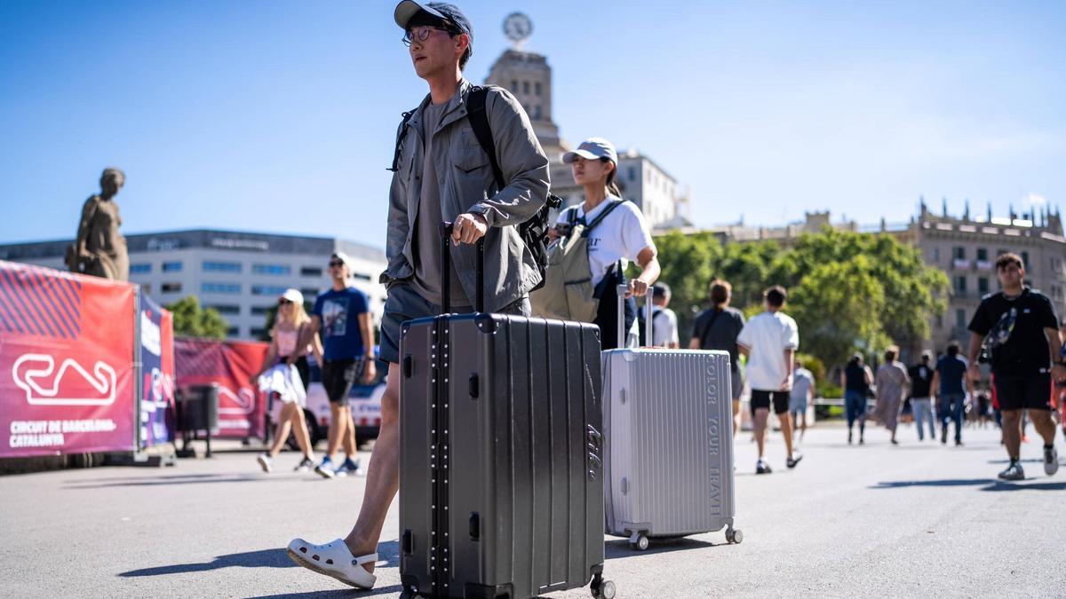 Turistas con maletas por el centro de Barcelona.