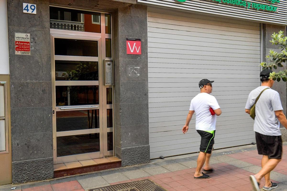 Dos personas pasan por delante de una vivienda vacacional.