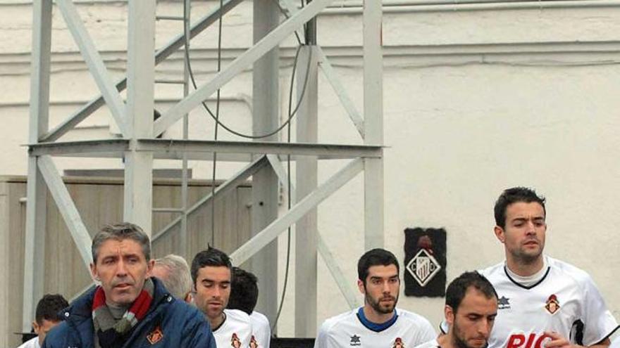 Paco Fernández, a la izquierda, mientras los jugadores del Caudal salen del vestuario del Hermanos Antuña.