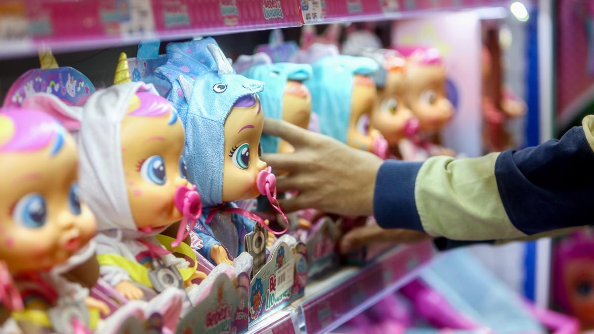 Ein Mitarbeiter eines Spielzeugladens in Madrid stellt Puppen in ein Regal.