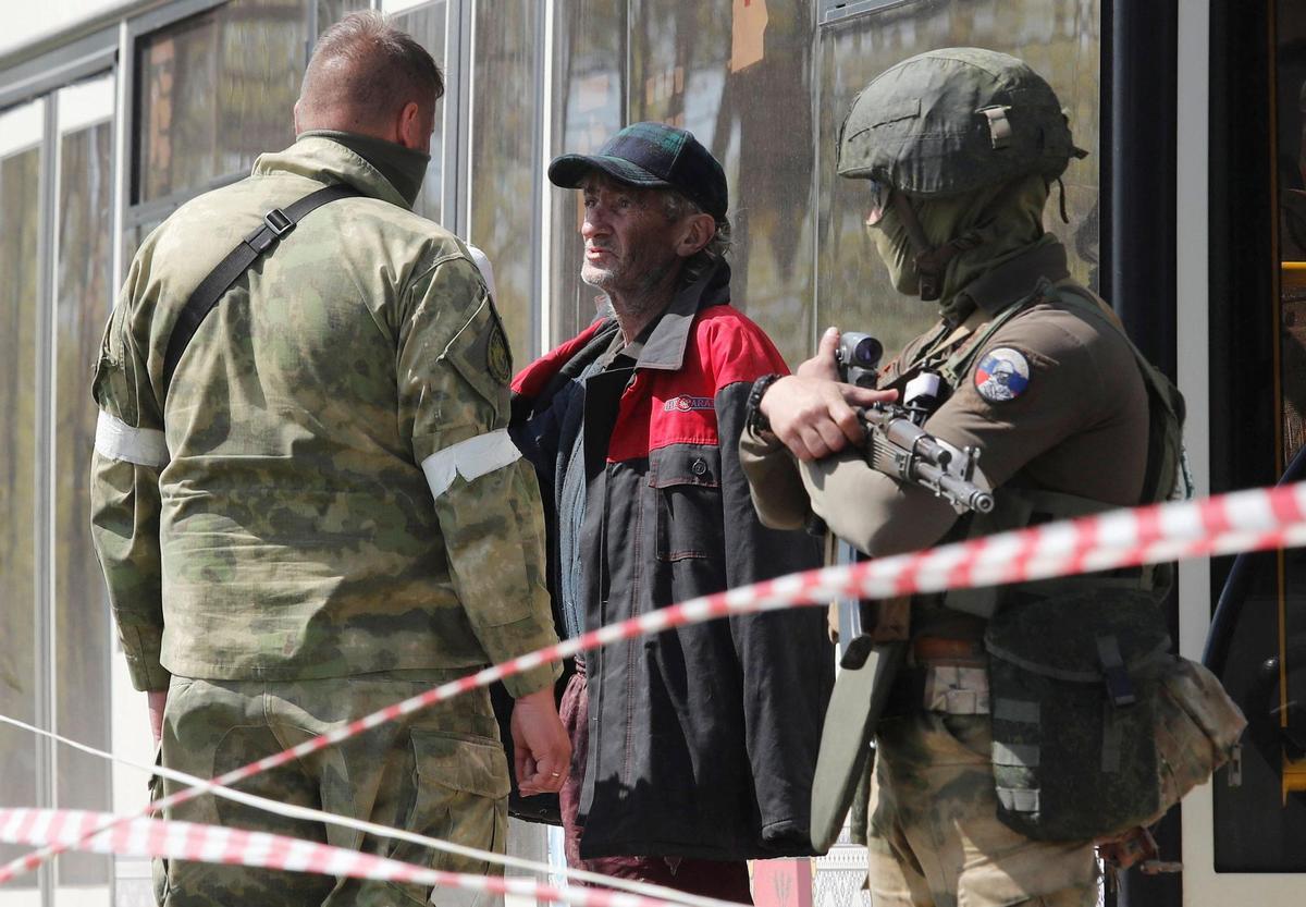 Civiles abandonan la zona cercana a la planta siderúrgica de Azovstal en Mariupol.