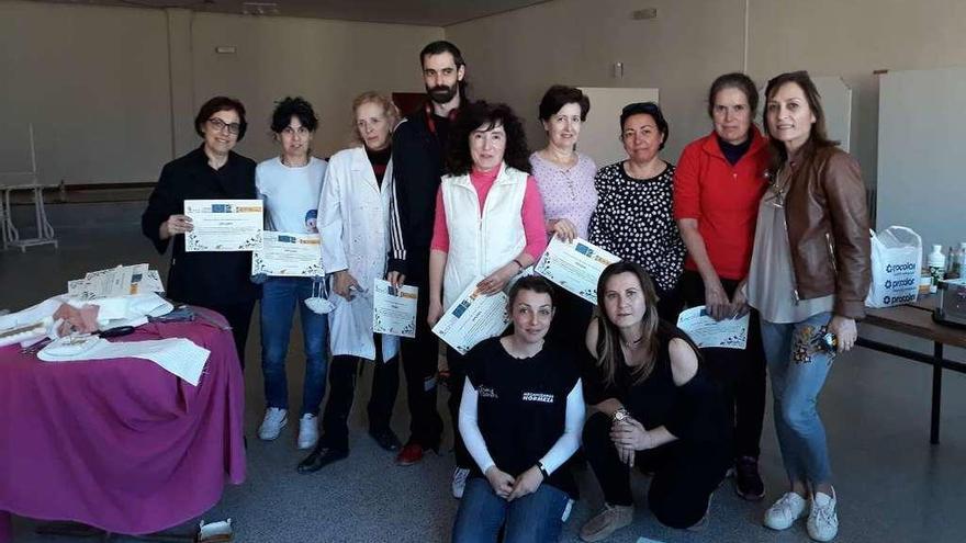 Los participantes en el curso posan con sus títulos de acreditación