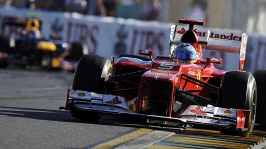 Fernando Alonso rueda con su Ferrari por delante del Red Bull de Mark Webber durante las primeras vueltas del GP de Australia. | frank robichon / efe