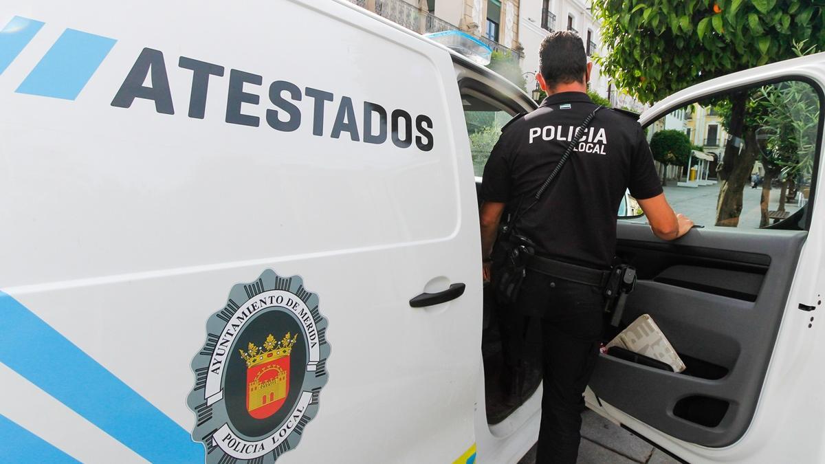 Un agente de la Policía Local de Mérida se dispone a subir a un vehículo.