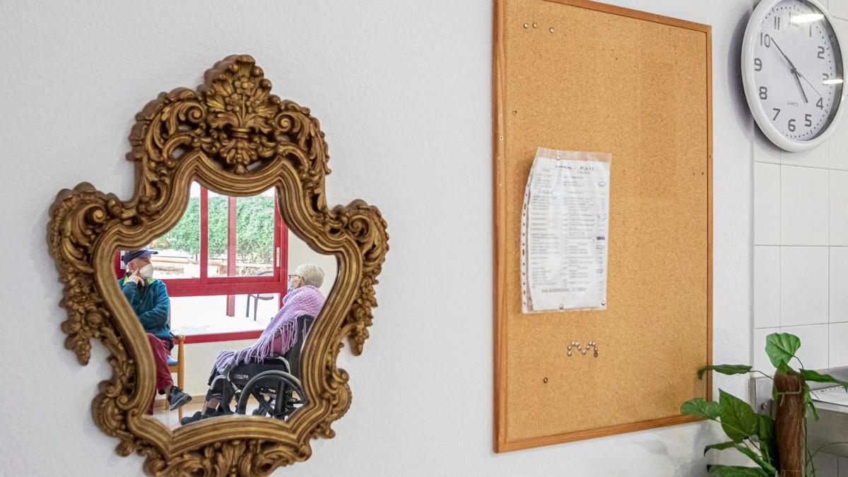 Dos personas, fotografiadas ayer en la residencia de mayores de San Basilio, en Murcia. | ABEL F. ROS