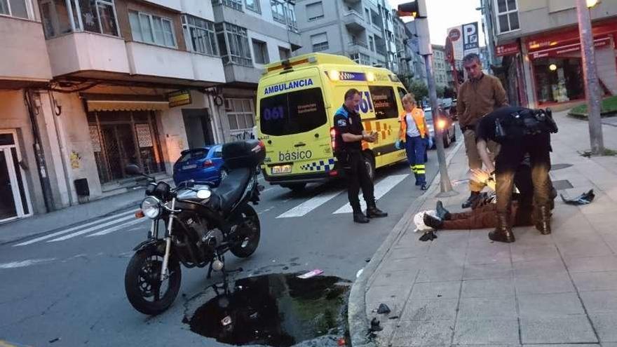 Un agente se interesa por el estado del motorista tirado en el suelo. // FdV