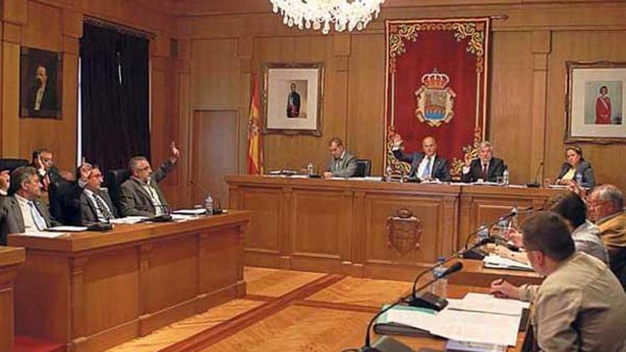 Diputados del PP y del PSOE, a derecha e izquierda de Baltar, votan en el pleno de ayer.  // Jesús Regal