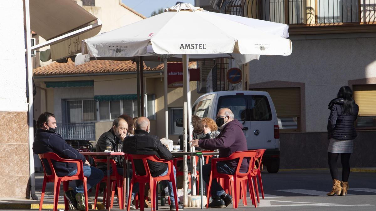 Vecinos de Bolbaite conversan en la terraza de un bar.