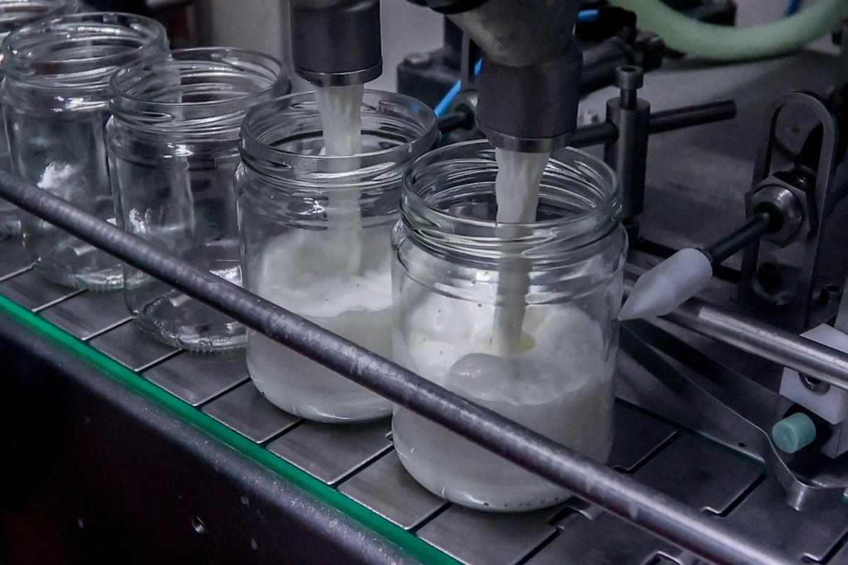 Una máquina llenando recipientes de leche.