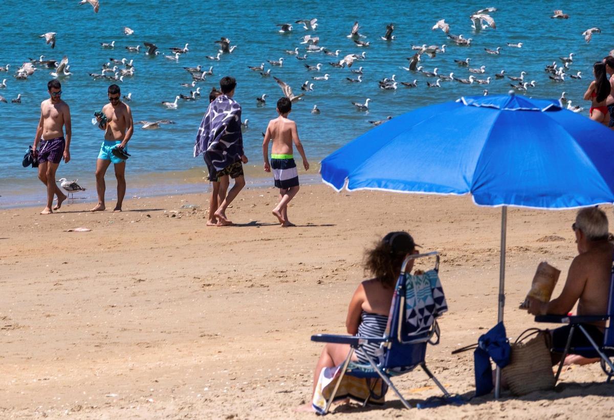 Personas en un soleado día en la playa del 'Barrio de pescadores' en Lepe