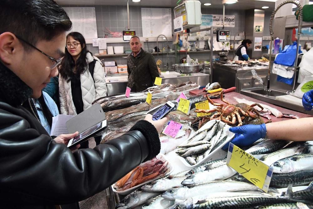 Una treintena de alumnos del Centro de Linguas de la Universidad coruñesa procedentes de China y Vietnam visitan el mercado de la plaza de Lugo para aprender argot gastrónomico gallego.