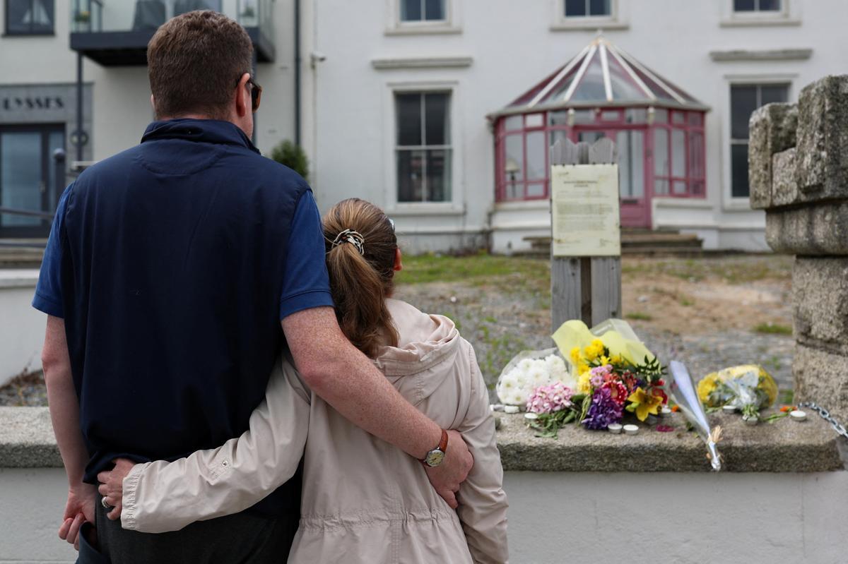 Dos personas se abrazan ante el homenaje para despedir a la fallecida cantante irlandesa Sinéad OConnor ante su casa en Bray, en la costa irlandesaín