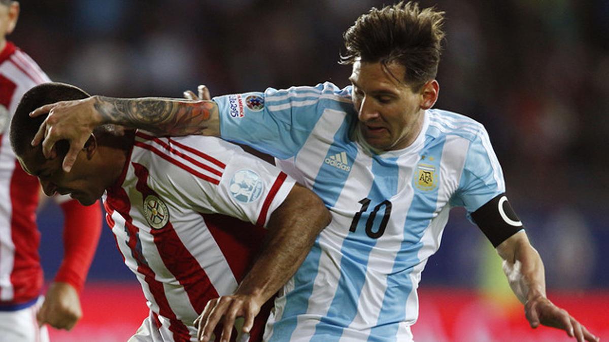 Leo Messi y Paulo Da Silva luchan por el balón durante el partido entre Argentina y Paraguay en la Copa América