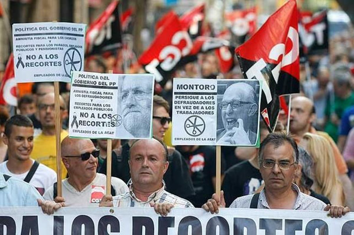 Els manifestants porten pancartes contra el president del Govern i el ministre d’Hisenda.