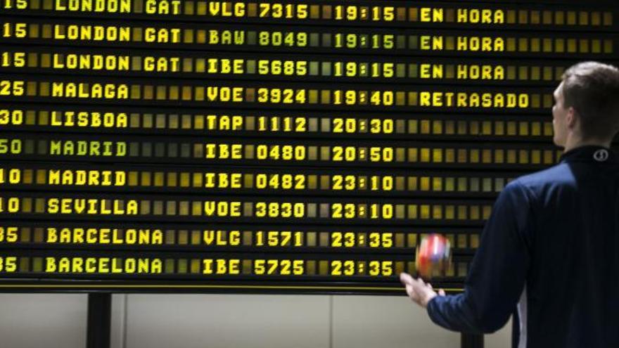 Un viajero consulta la pantalla de vuelos en el aeropuerto de Asturias.