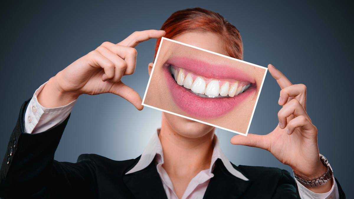Fotografía d'una dona amb la fotografía d'unes dents