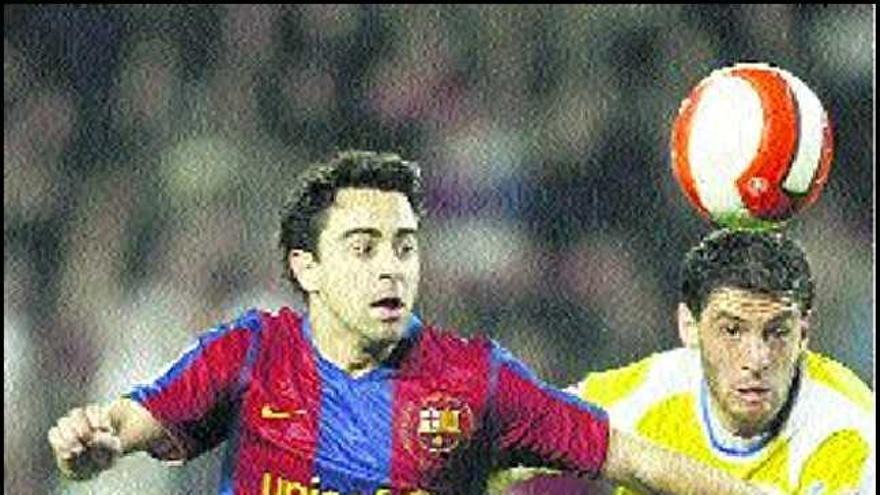 Xavi y Licht luchan por el balón en el partido de ayer en el Camp Nou.