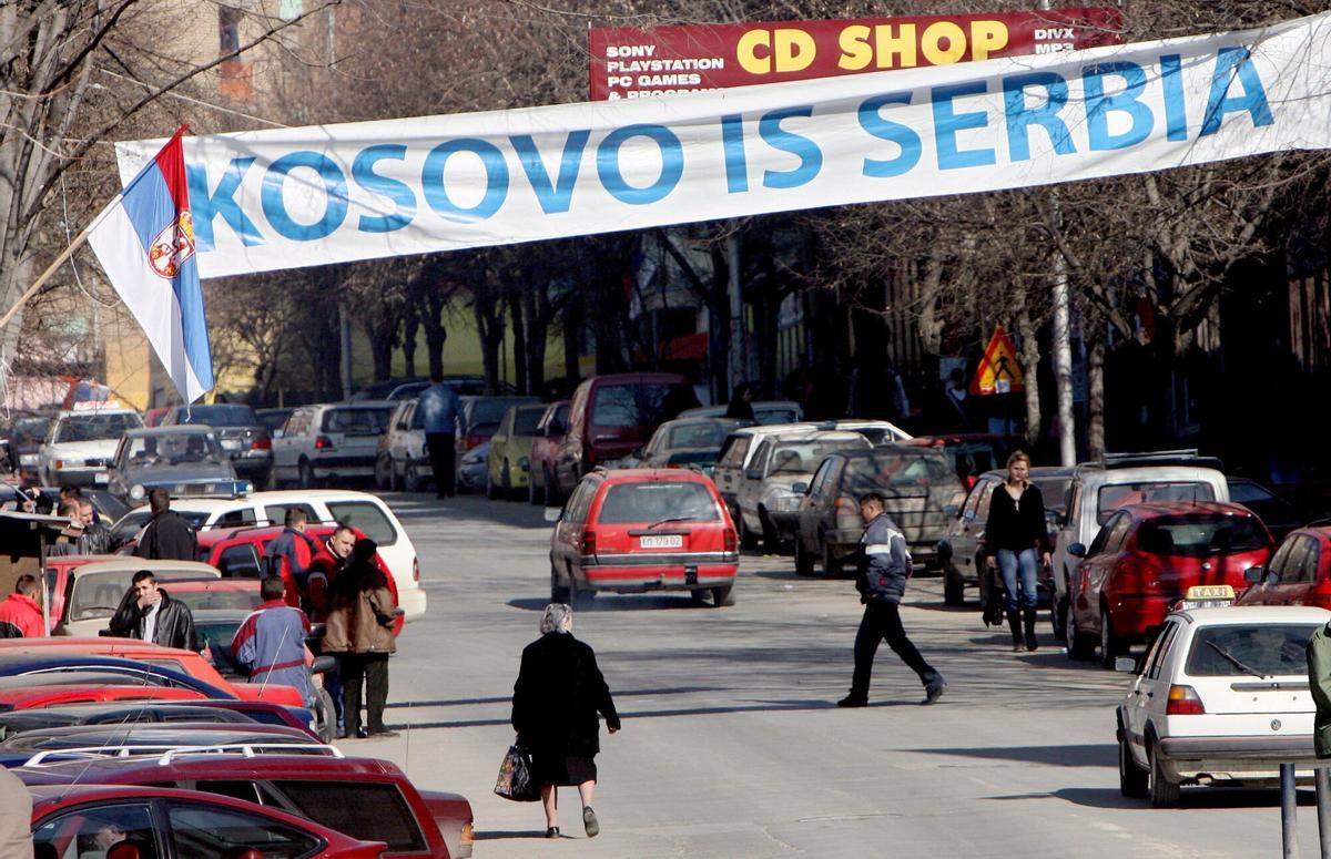VAL01. MITROVICA, 25/02/08.- Varias personas serbias caminan bajo una bandera que proclama "Kosovo es Serbia" en la parte norte de la ciudad étnicamente dividida de Mitrovica hoy lunes 25 de febrero. El parlamento de Kosovo declaró unilateralmente su independecia el pasado día 17 de febrero. Kosovo será sexto estado que surge del desmembramiento de la antigua Yugoslavia, que desde 1991 ha dado lugar a Eslovenia, Croacia, Macedonia, Bosnia y Montenegro, y Serbia. Desde 1999 Kosovo fue una región de la antigua Serbia bajo el protectorado de las Naciones Unidas tras la guerra librada entre las autoridades serbias y la guerrilla albanesa. EFE/Valdrin Xhemaj. POLITICA INTERNACIONAL. DISTURBIOS. PROCESOS DE INDEPENDENCIA. PROTESTAS. RADICALES. SERBOKOSOVARES