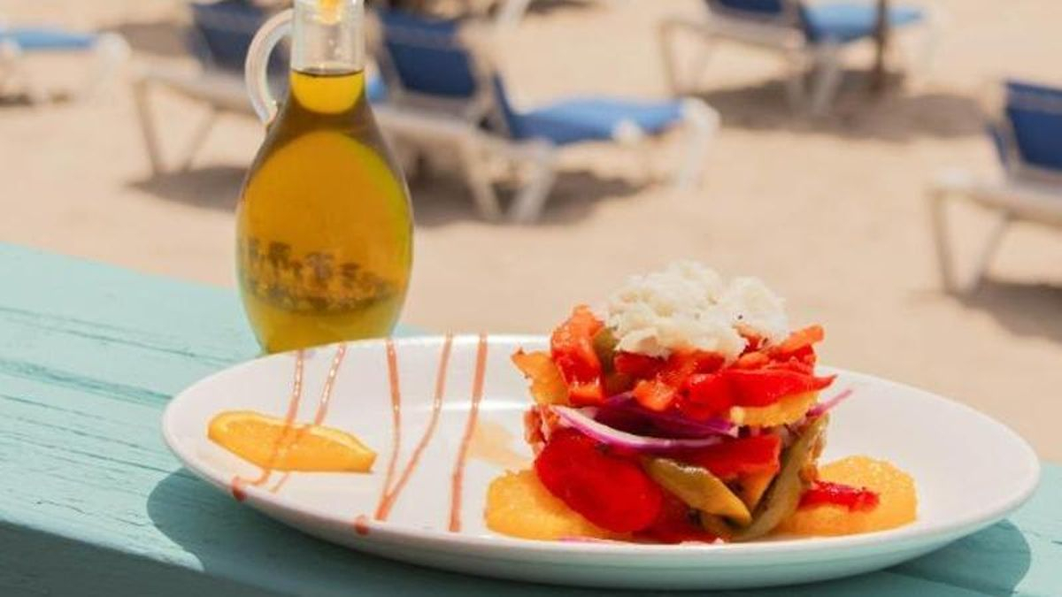 Timbal de pimientos asados, cebolla, naranja y bacalao ahumado, con vistas a la playa de La Victoria.