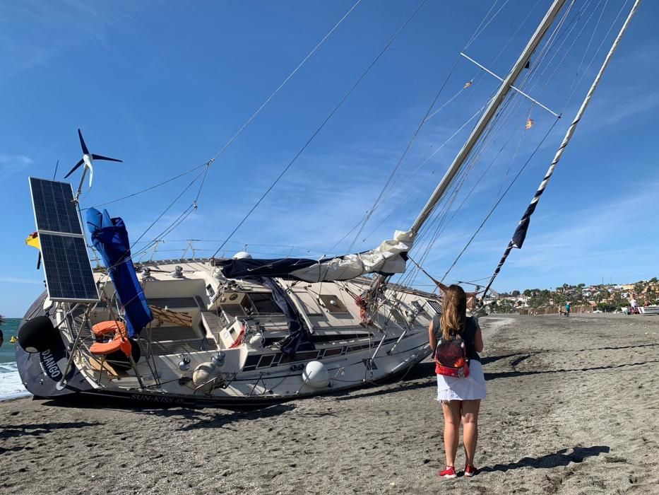 El velero Django quedaba varado en la playa de Benajarafe, el pasado viernes. A la espera de ser remolcado, el barco se ha convertido en una atracción para paseantes y bañistas, que fotografían la peculiar estampa.