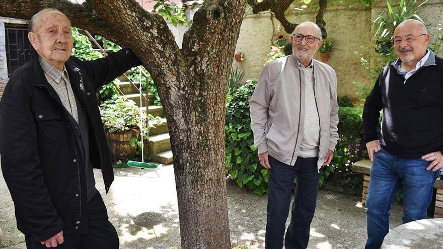 Salvador Farrés, de 100 anys, es repenja en un arbre del pati de casa seva, al barri Vic-Remei; mentre l&#039;observen el seu amic Joan Cals, de 86 anys, i el cineasta Enric Roca